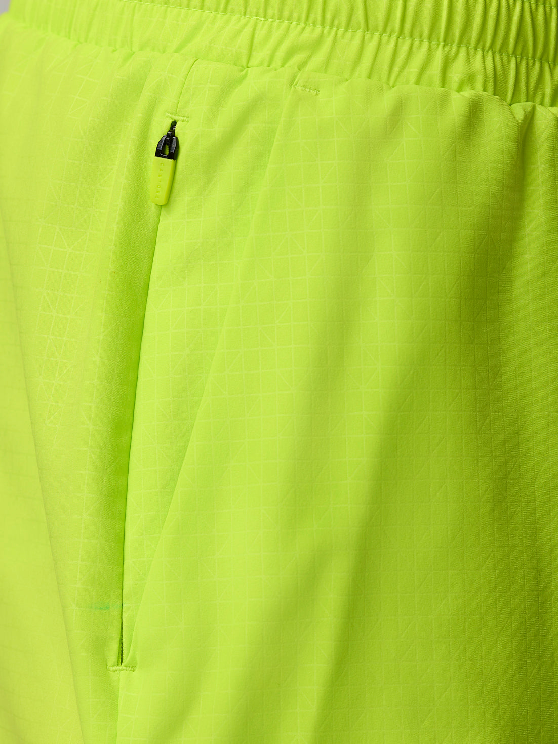 Close-up of a lime green zip pocket on Adapt Swim Shorts fabric