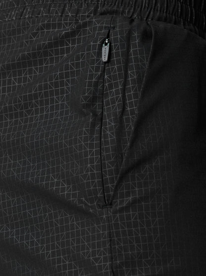 Close-up of black Adapt Swim Shorts showing the zip pocket and grid fabric pattern.