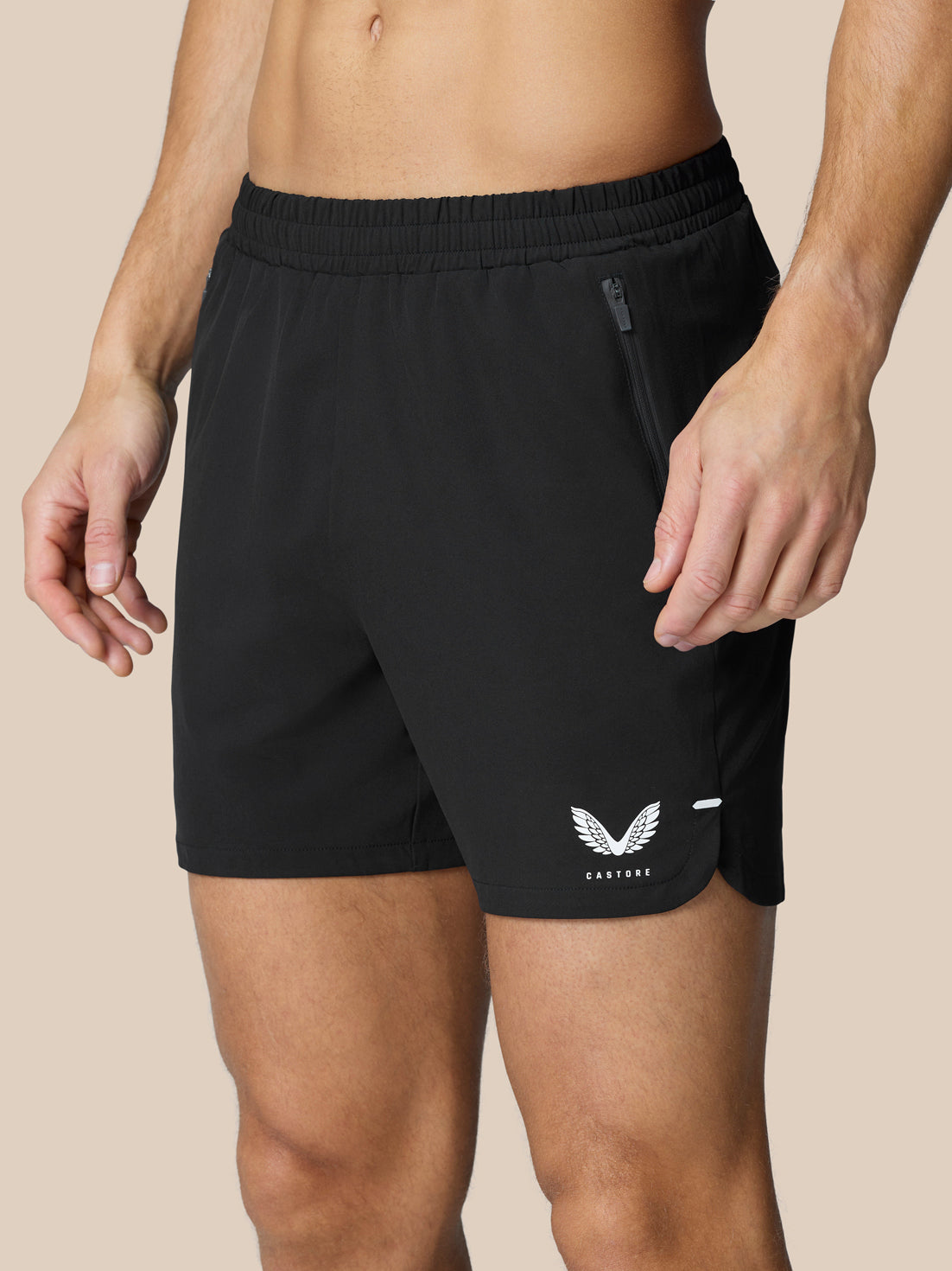 Close-up of black Flow Training Shorts waist area showing elastic waistband and side zip pocket.