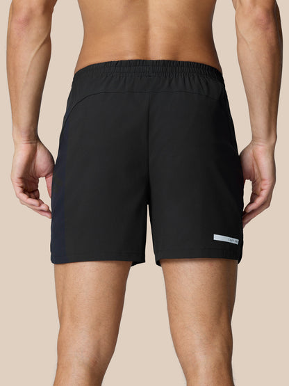 Back view of black Flow Training Shorts featuring elastic waistband and CASTORE logo at hem.