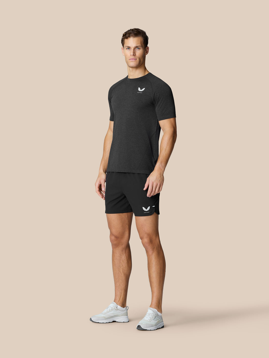 Male model wearing black Flow Training Shorts with white logo on left leg and a dark athletic shirt.