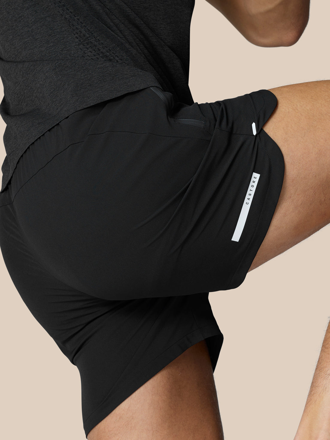 Close-up of black Flow Training Shorts showing a side zip pocket and smooth woven fabric