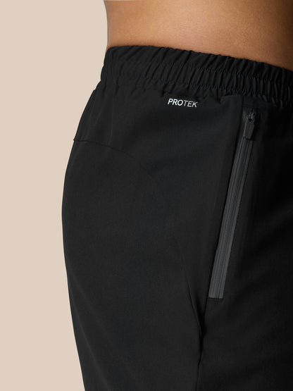 Side view of black Flow Training Shorts with a vertical zip pocket and ProTek branding on the waistband