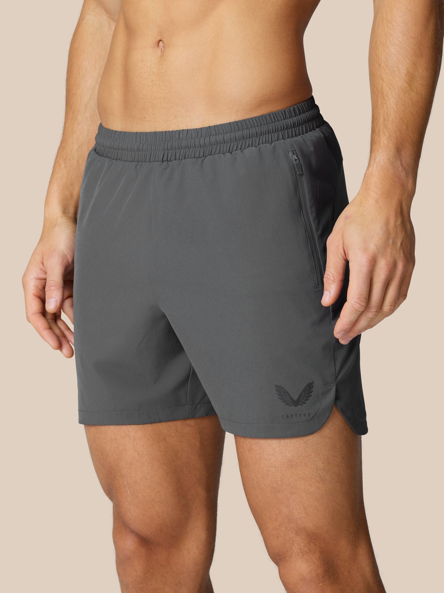 Flow Training Shorts gunmetal waist close-up with elastic waistband side zip pocket and logo on the leg