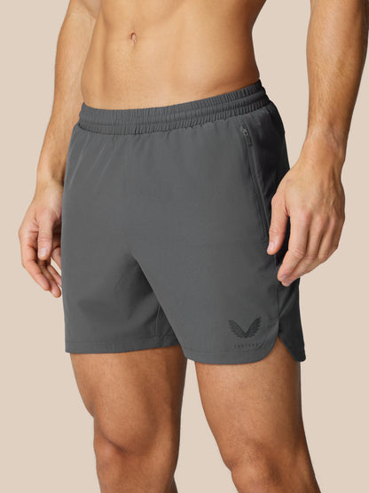 Flow Training Shorts gunmetal waist close-up with elastic waistband side zip pocket and logo on the leg
