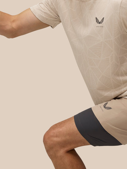 Beige Flow 2-in-1 shorts on a model with the inner black liner visible and a logo on the thigh