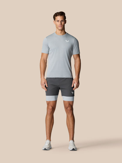 Male model wearing Flow Training 2-In-1 Short in mid grey with a lighter underlayer visible.