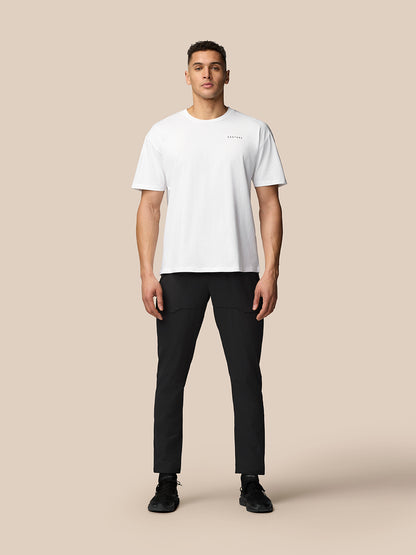 Full body front view of male model wearing white T shirt and black Flex Lifestyle Cargo Trousers showcasing cargo pockets.