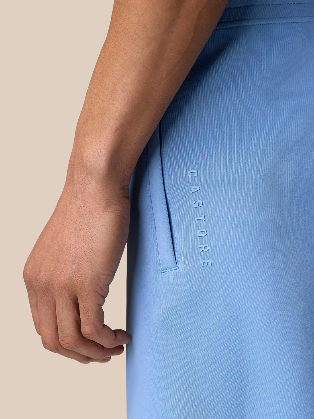 Close-up side view of sky blue Flex Shorts showing vertical Castore branding along the leg
