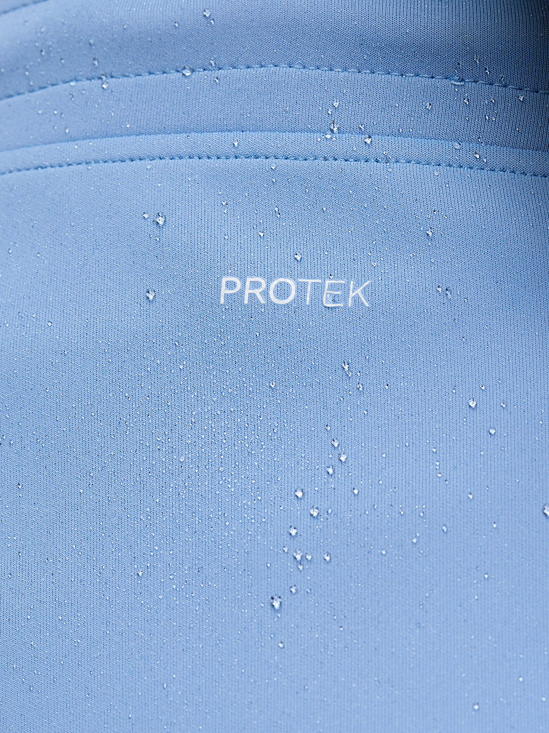 Close-up of sky blue Flex Shorts ProTek fabric with water droplets and seam details