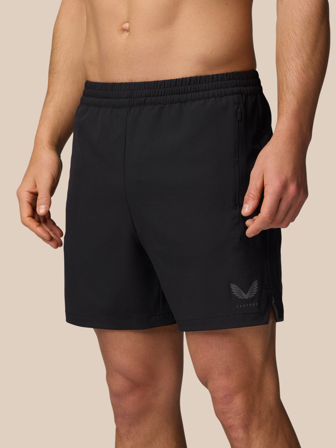 Model wearing black Apex 6 inch training shorts with elastic waistband and zipped side pocket.