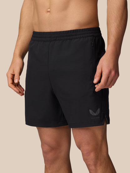 Model wearing black Apex 6 inch training shorts with elastic waistband and zipped side pocket.