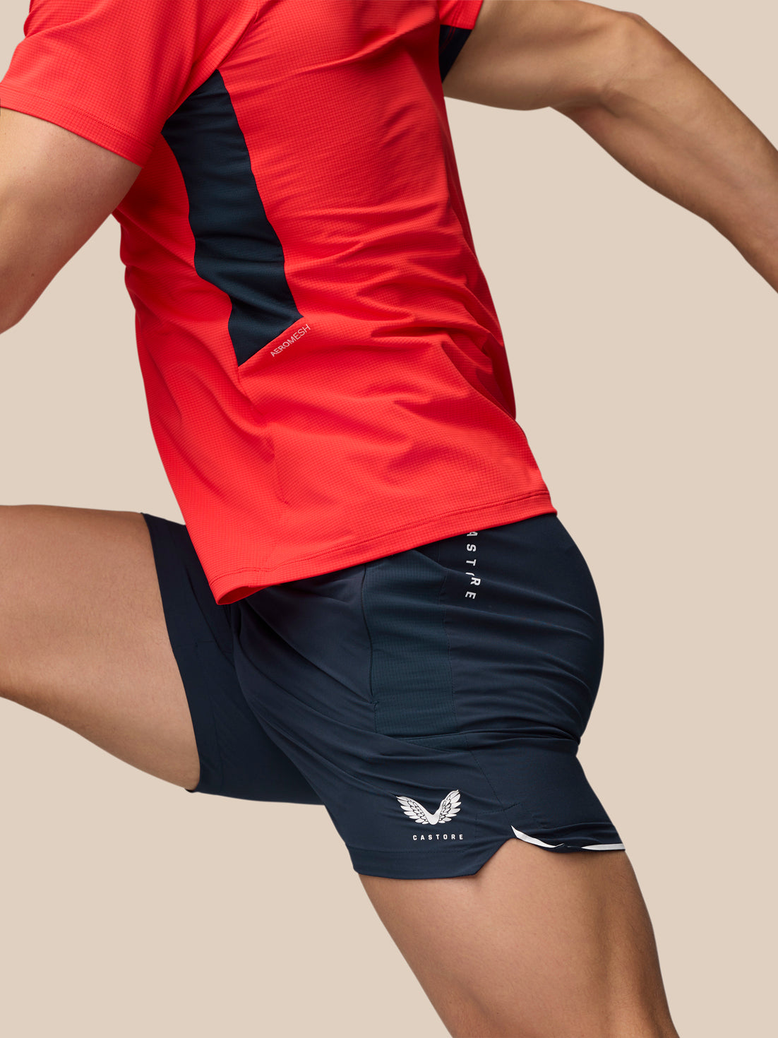 Side view of a person wearing Apex Training Shorts in Midnight Navy with a red athletic shirt