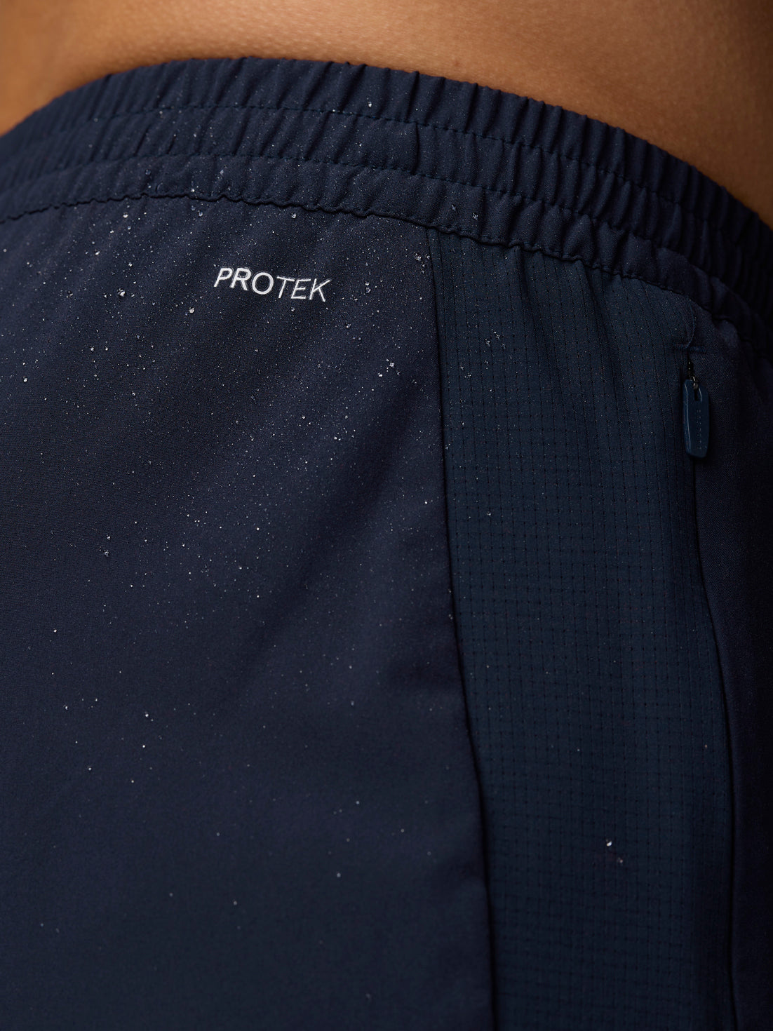 Close-up of midnight navy Apex Training Shorts waistband with Protek logo and a zipped pocket
