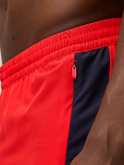 Close-up of red Apex Training Shorts waistband with elastic band and a zip pocket