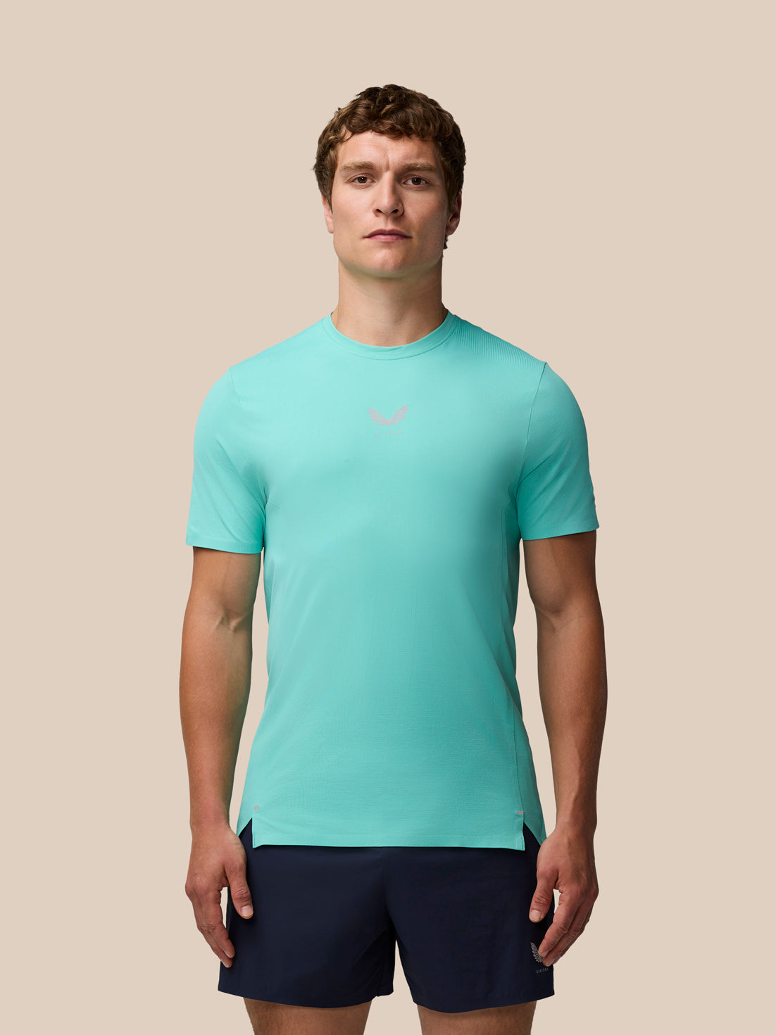 Man wearing light aqua Zone Training T-Shirt with a small chest logo and navy shorts.