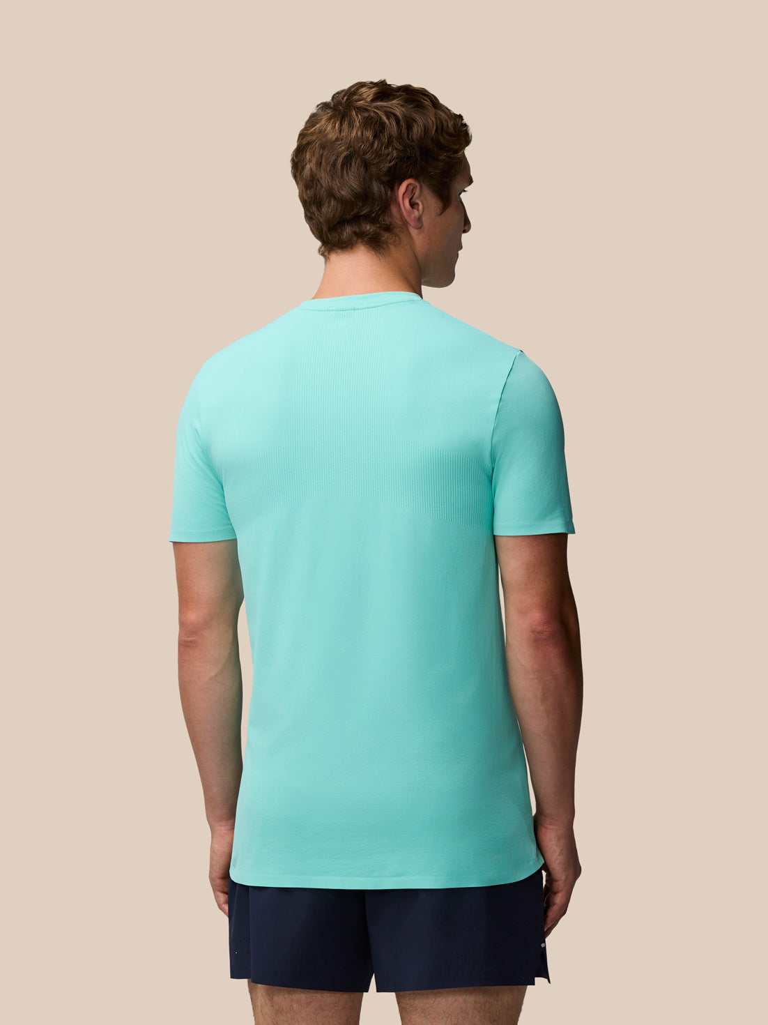 Back view of a man wearing Zone Training T-Shirt in Light Aqua with subtle back ribbing.