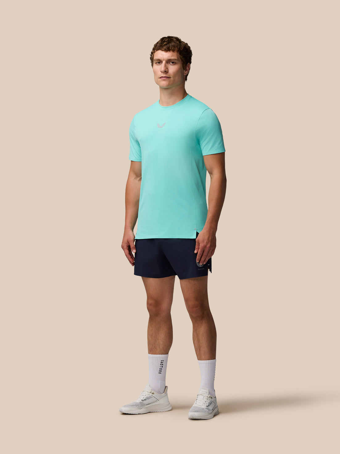 Full-body front view of a man in Light Aqua Zone Training T-Shirt and navy shorts.