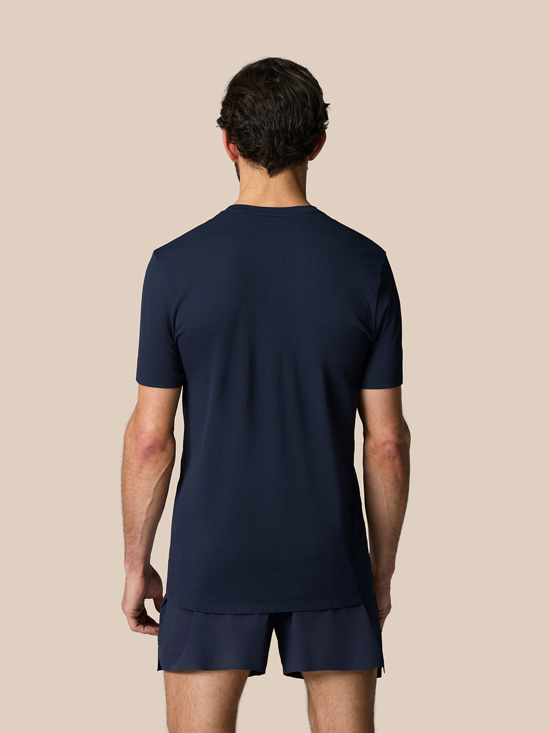 Back view of male model in Midnight Navy Zone Training T-Shirt showing ribbed back panel