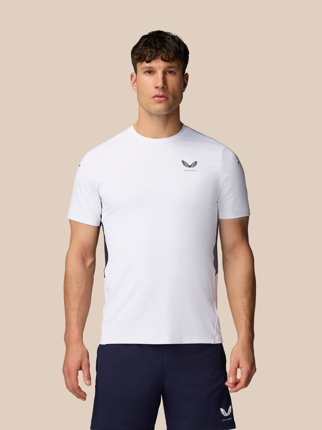 Front view of a male model wearing a white Apex Training T-Shirt with a crew neck and navy shorts.