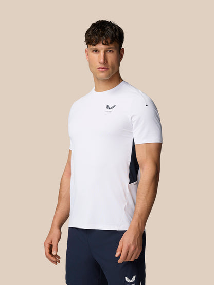Side profile of a man in a white Apex Training T-Shirt with navy side panels