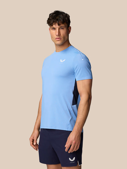 Male model wearing Apex Training T-Shirt in Sky Blue with navy side panels