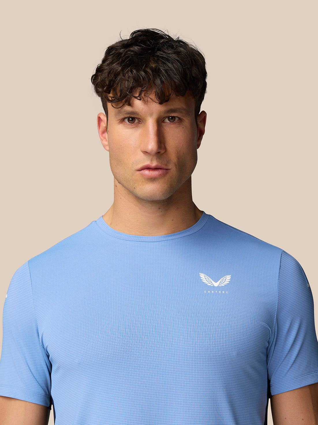 Front view of a man wearing Sky Blue Apex Training T-Shirt with white Castore wing logo on the left chest