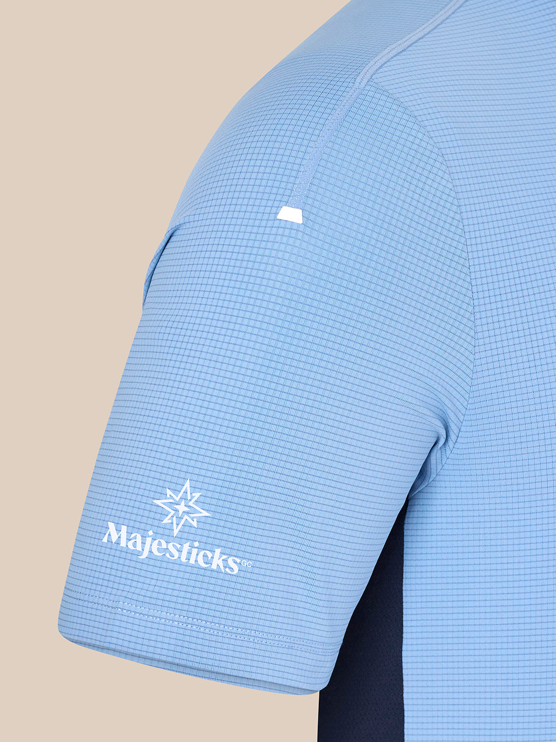 Close-up of sky blue Majesticks T shirt sleeve with grid fabric and Majesticks logo near the cuff