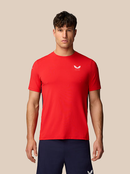 Male model wearing red Apex Training T Shirt with white Castore logo on chest and navy shorts