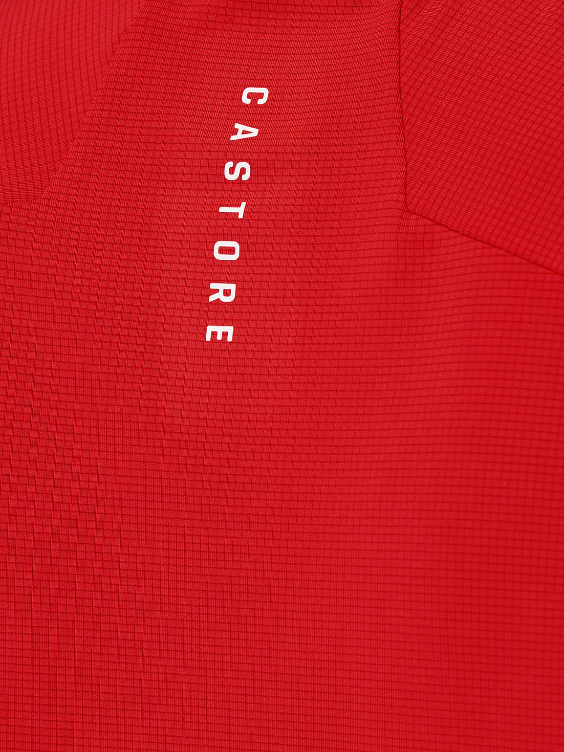 Close-up of red Apex Training T-Shirt fabric showing a grid texture and vertical Castore branding.