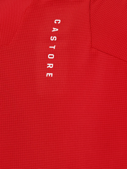 Close-up of red Apex Training T-Shirt fabric showing a grid texture and vertical Castore branding.