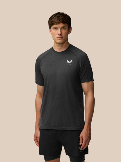 Man wearing black Flow Training T Shirt with white logo on the chest against a beige backdrop