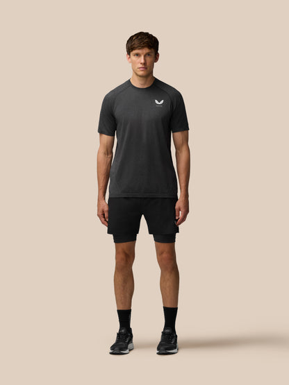 Flow Training T-Shirt in black worn by a male model front view showing seamless knit and small left chest logo
