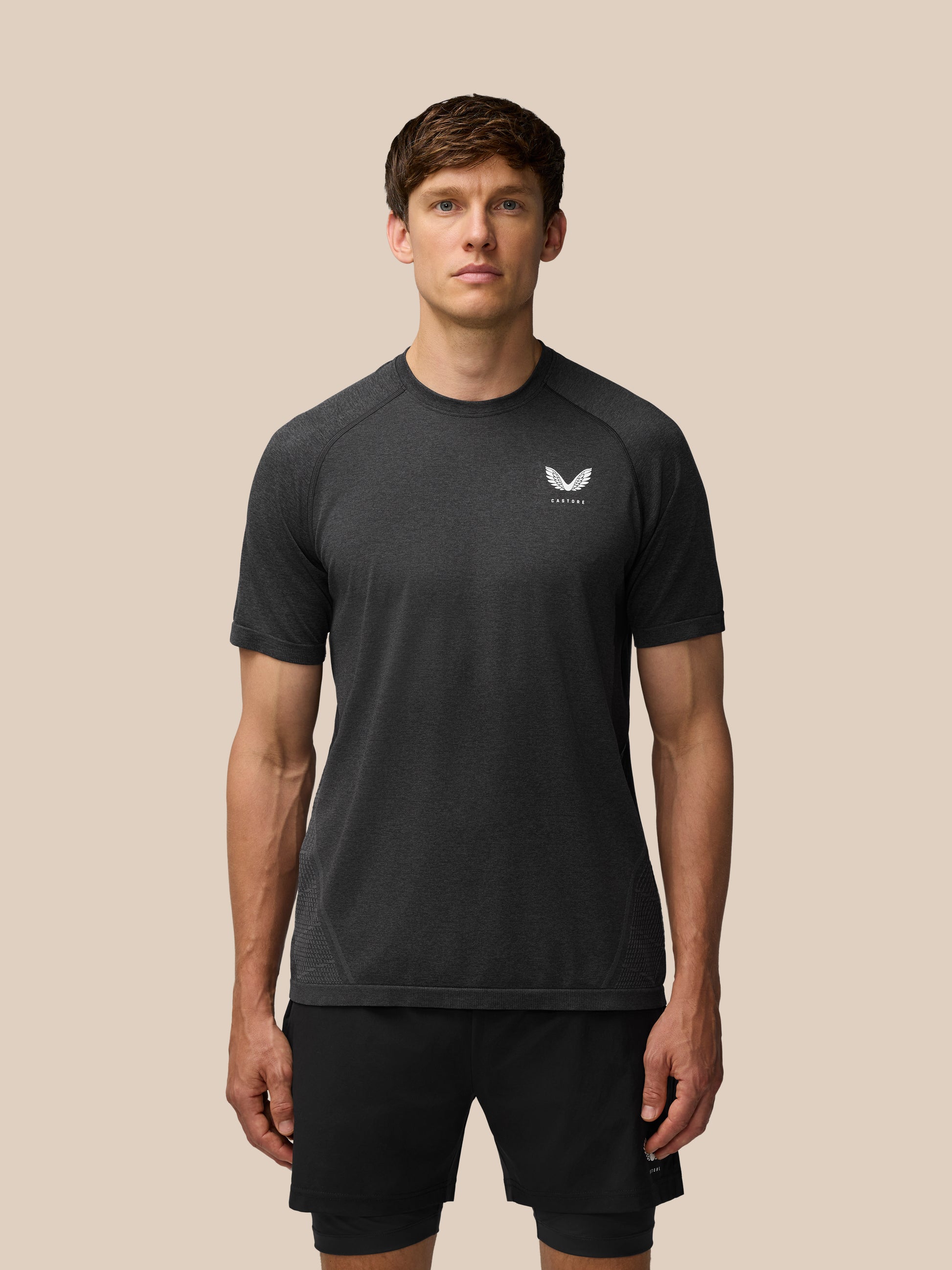 Flow Training T Shirt in black worn by a model front view with small chest logo and seamless knit texture
