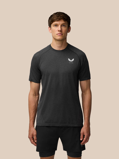 Flow Training T Shirt in black worn by a model front view with small chest logo and seamless knit texture