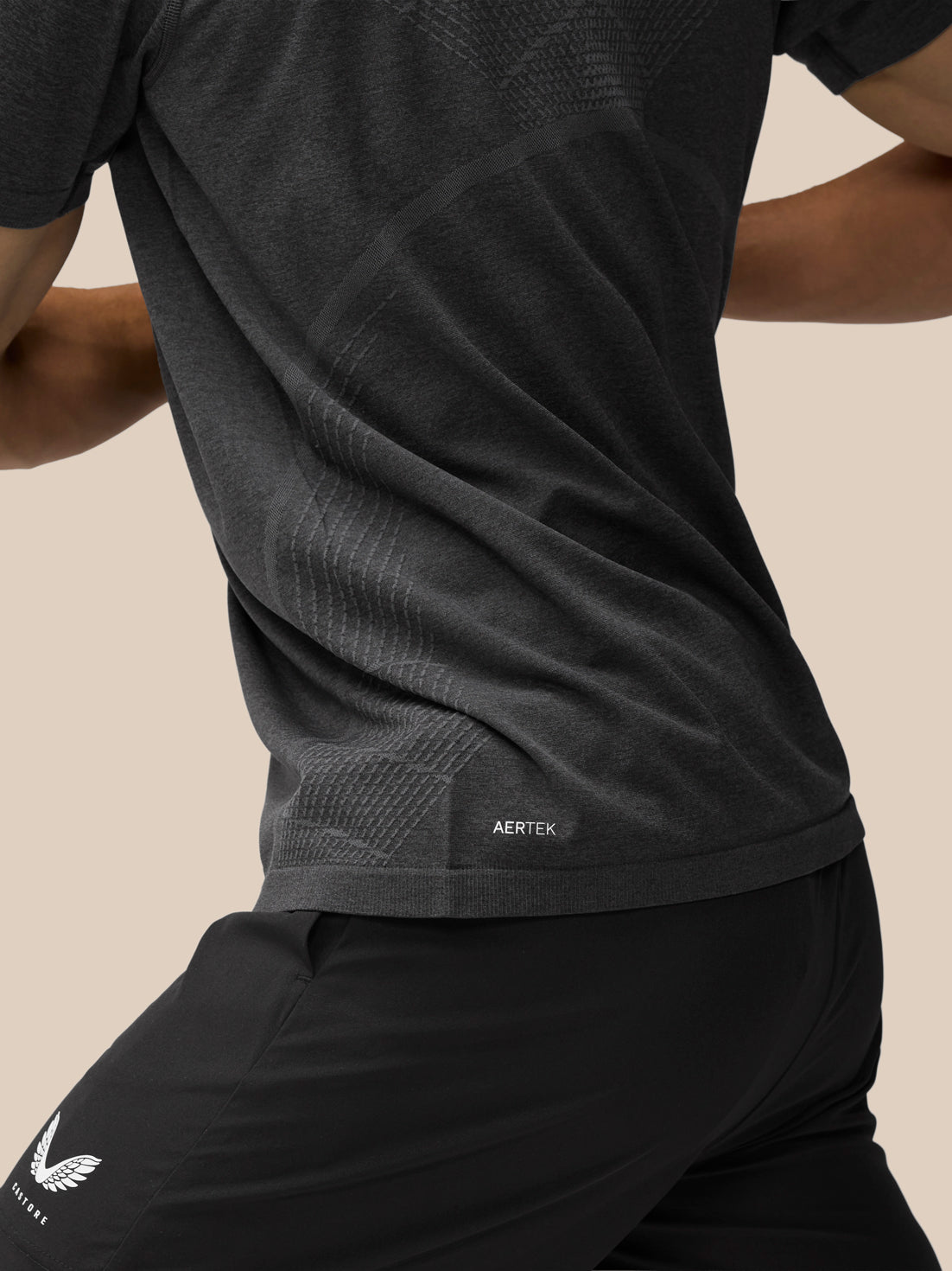 Back close-up of Flow Training T-Shirt in black showing seam panels and AerTek label at the hem