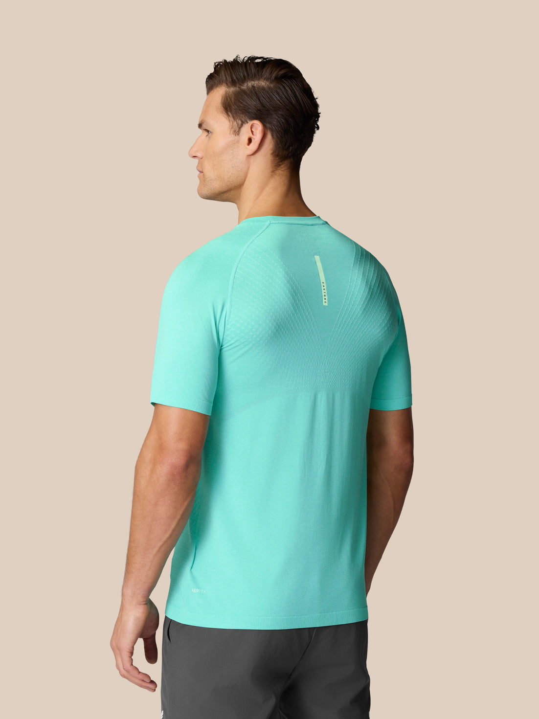 Back view of Flow Training T-Shirt in light aqua on a model with logo on the upper back