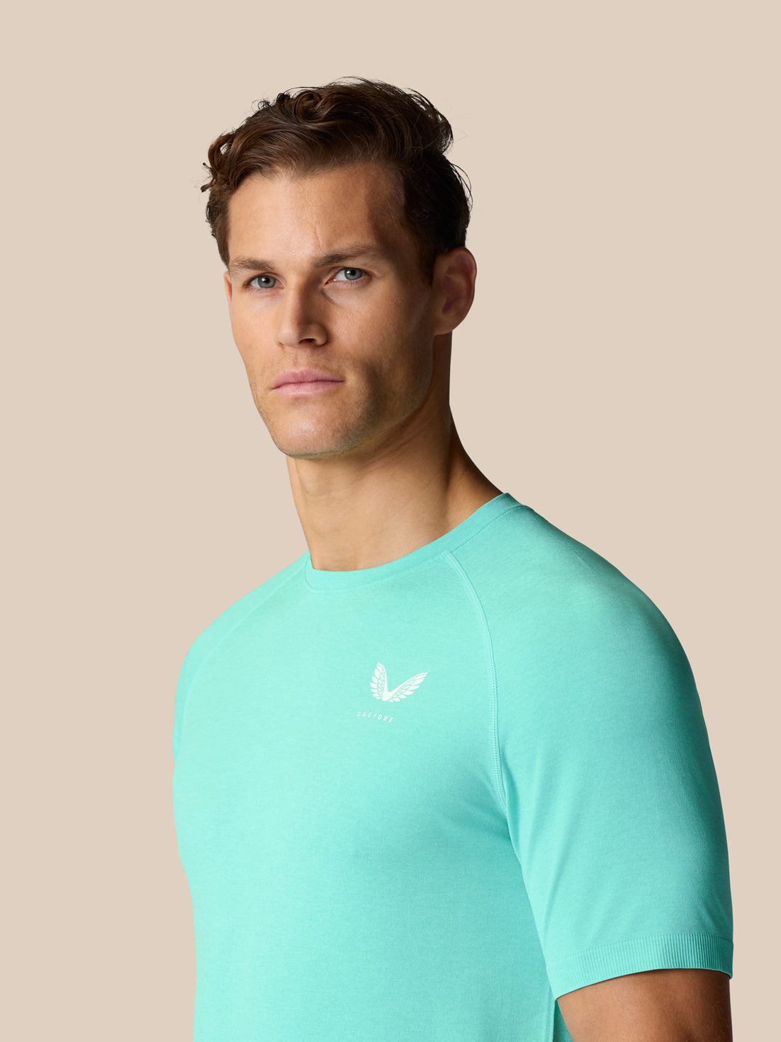 Three-quarter view of a man wearing light aqua Flow Training T Shirt with a small white logo on the chest