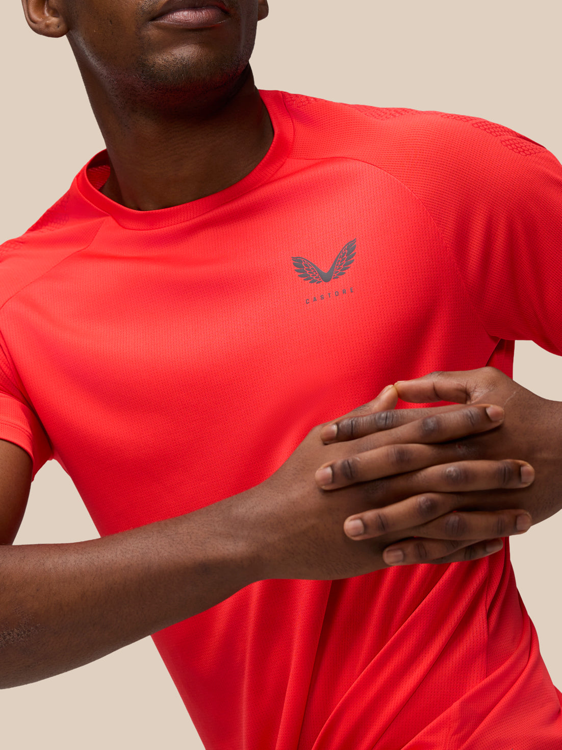 Front chest close up of red Flow Training Muscle Grip T Shirt with Castore logo and textured fabric detail