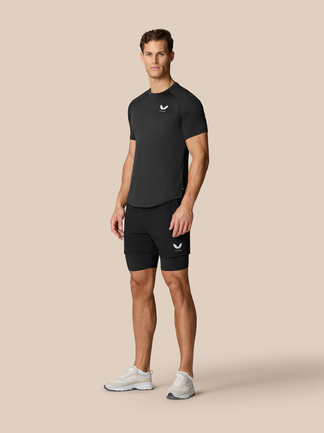 Male model wearing black Flow Training Muscle Grip T Shirt and matching shorts, front view.