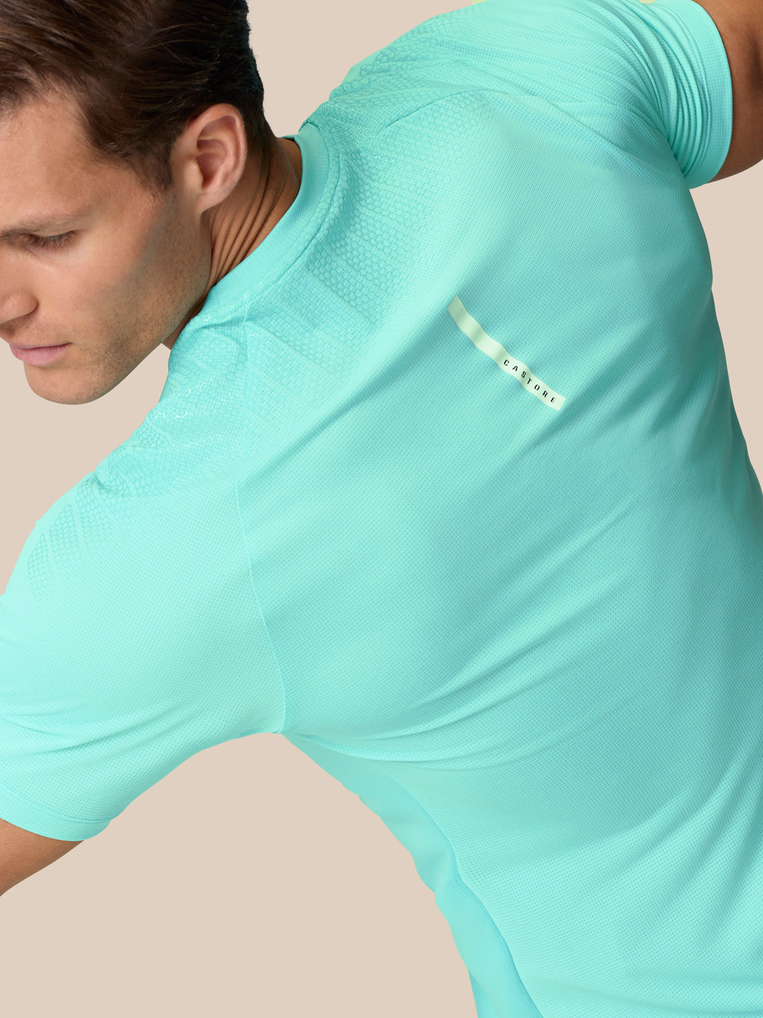 Close up of Light Aqua Flow Training Muscle Grip T-Shirt fabric highlighting texture and reflective back detail.