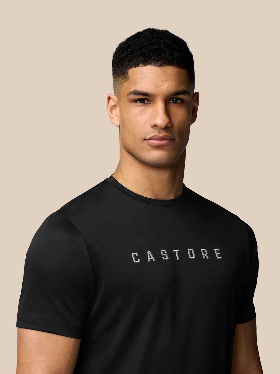 Close up of the chest on a black Castore graphic training T shirt displaying the logo