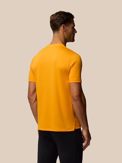 Rear view of a man in mango orange short sleeve training T shirt showing back of the garment