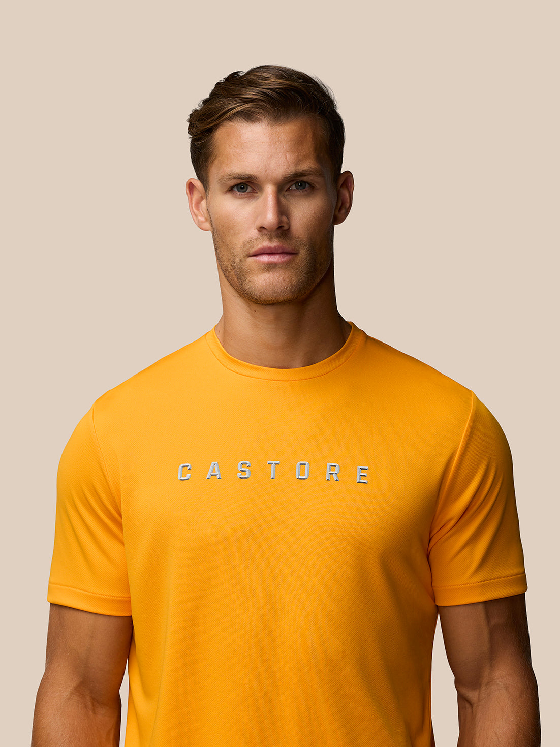 Close-up of male model wearing Mango graphic training T-shirt with Castore logo centered on the chest.
