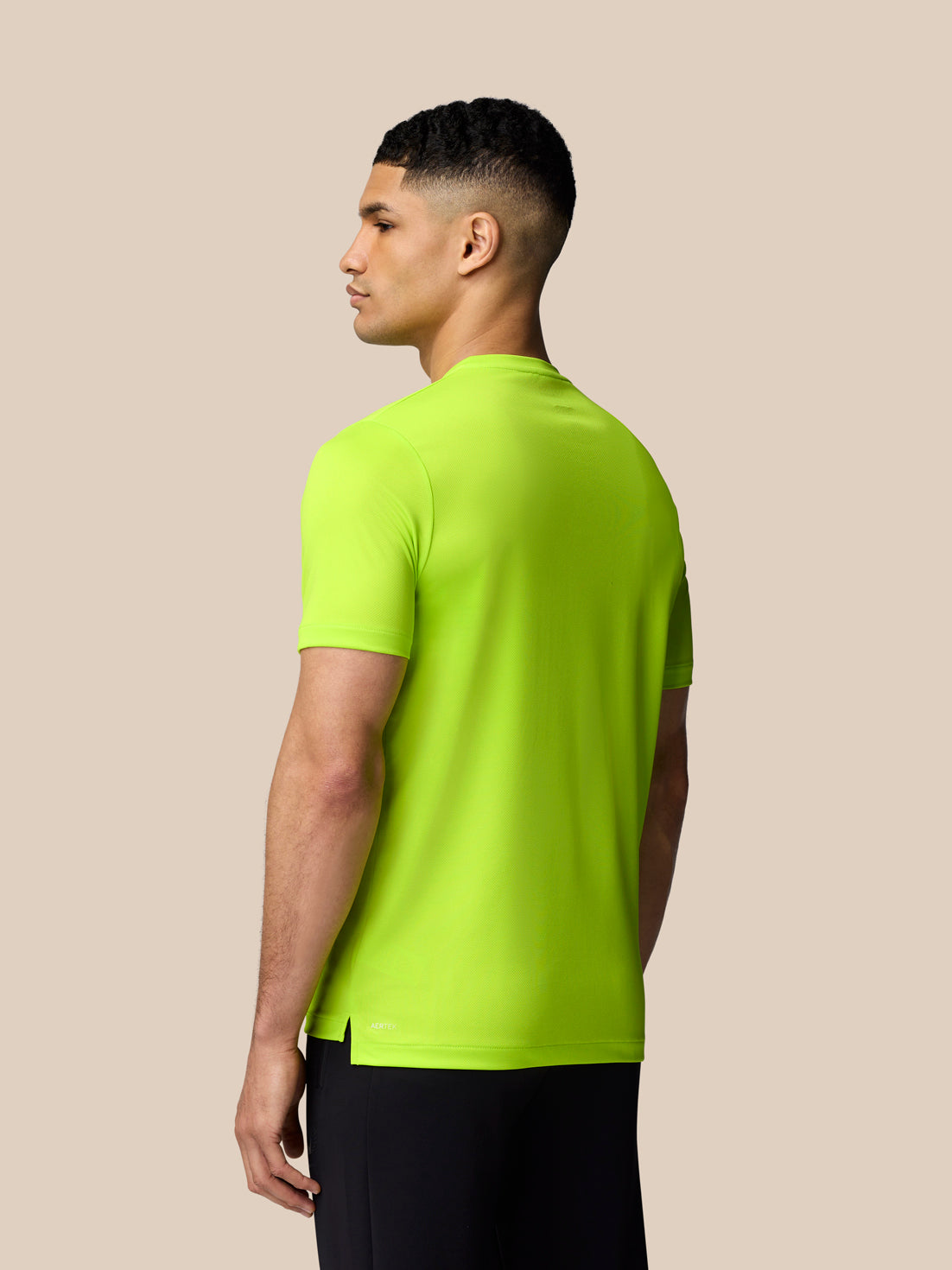 Back view of Acid Lime Graphic Training T Shirt on a male model showing the split hem detail