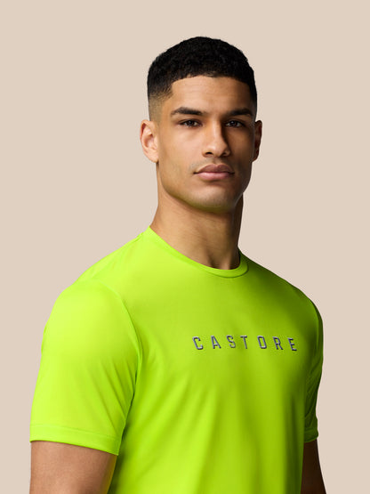 Close-up of male model wearing neon lime Castore Graphic Training T-Shirt with crew neck and a bold logo on the chest