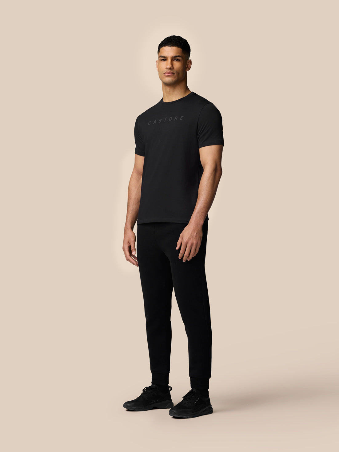 Front view of a man wearing a black Castore graphic lifestyle T-shirt and black joggers