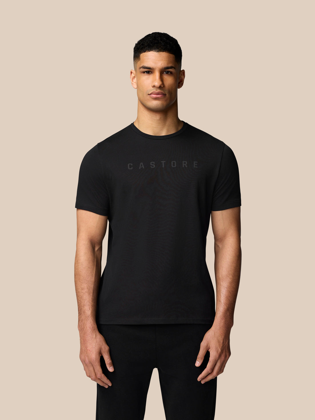 Front view of a man in a black Castore graphic lifestyle T-shirt