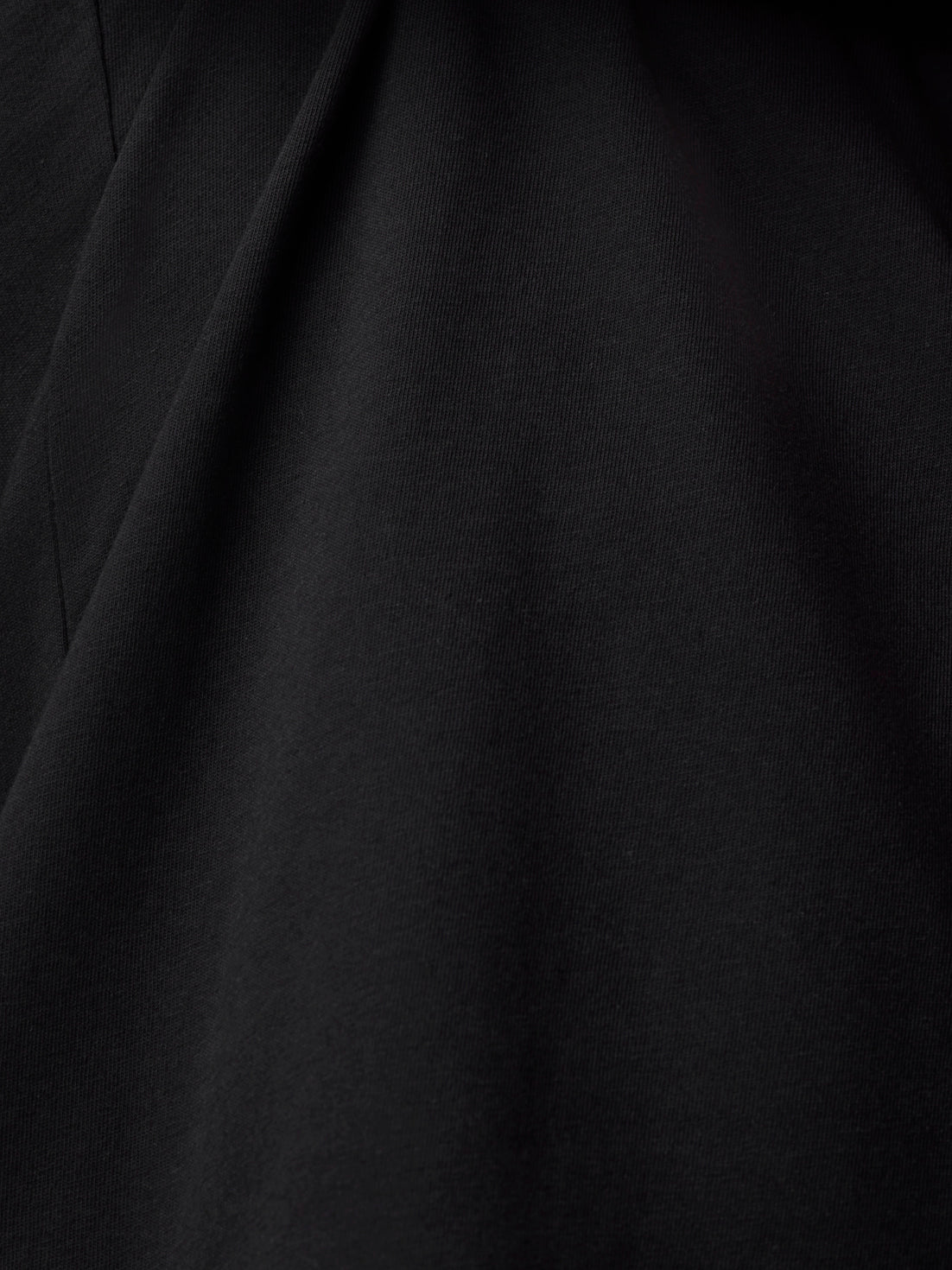 Close up of black cotton fabric with subtle texture and drape