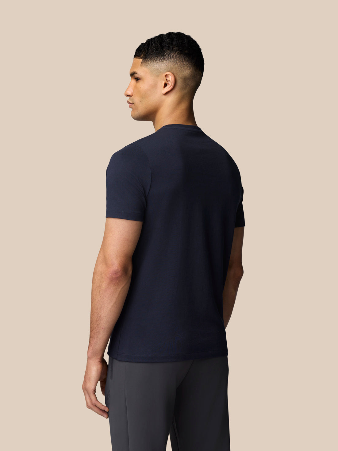 Rear view of navy graphic short sleeve T shirt on male model.